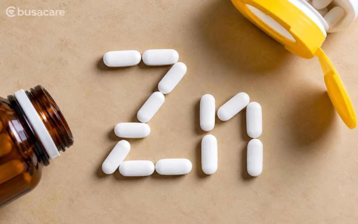 Tablet putih di samping botol obat dan perlengkapan kesehatan sebagai ilustrasi suplemen mineral zinc untuk mendukung kesehatan tubuh.