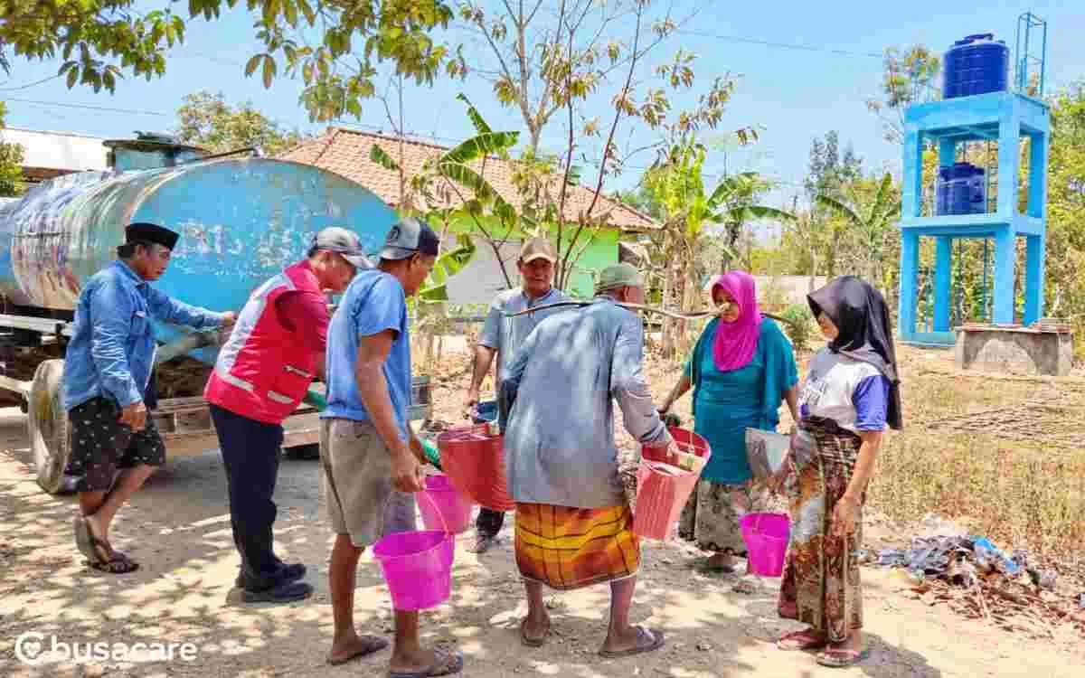 Petugas PMI Sumenep menyalurkan air bersih kepada 750 warga Desa Prancak menggunakan mobil tangki, dengan warga membawa ember untuk mendapatkan bantuan air bersih.