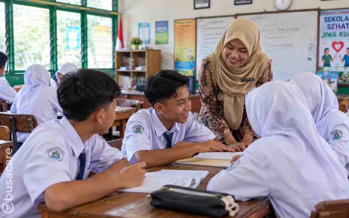 Guru mendampingi siswa belajar bersama di kelas untuk mendukung kesehatan mental dan mewujudkan sekolah aman serta nyaman.