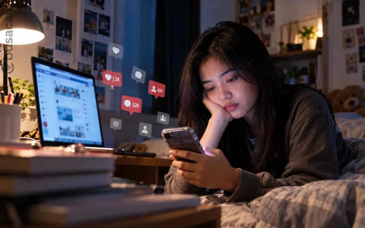 Seorang perempuan menggunakan ponsel di kamar sambil melihat media sosial, ilustrasi tantangan kesehatan mental di era digital antara konektivitas sosial dan kesepian modern.